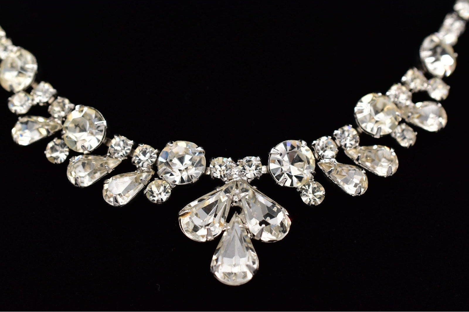 Silver necklace with clear crystals on a black background