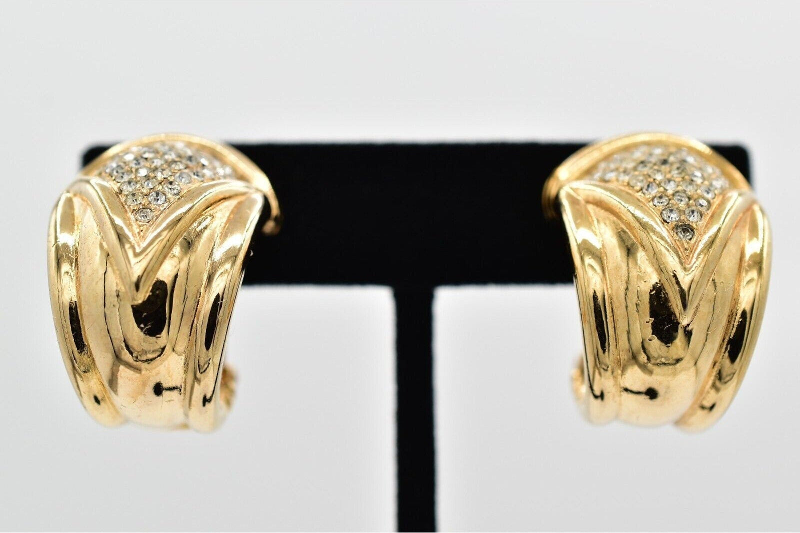 Gold hoop earrings with a clear gemstone on a white background