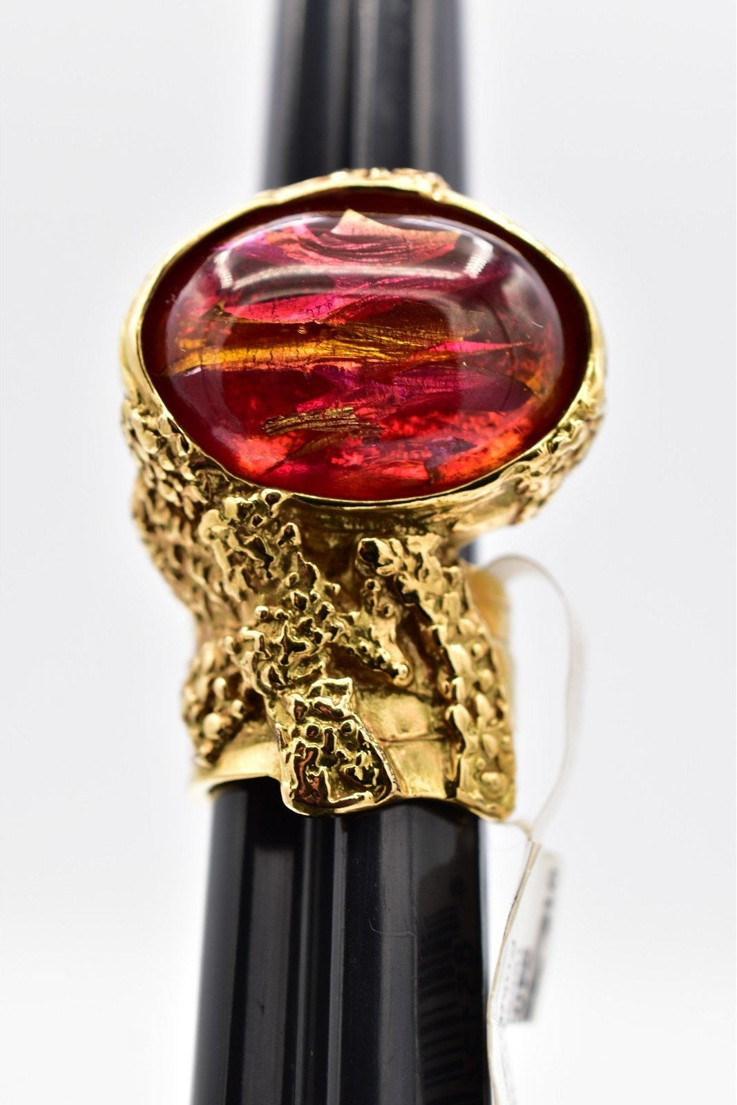 Decorative pen with gold cap featuring a red gemstone on a white background