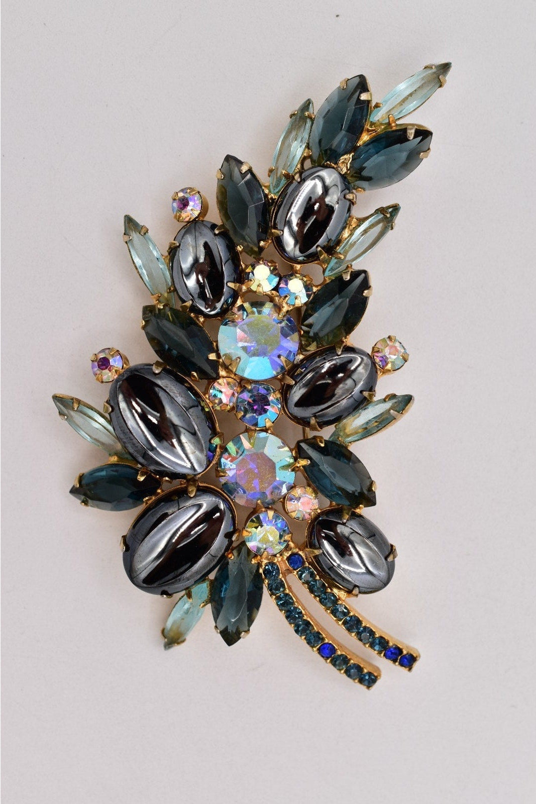 Decorative brooch with gemstones on a light gray background