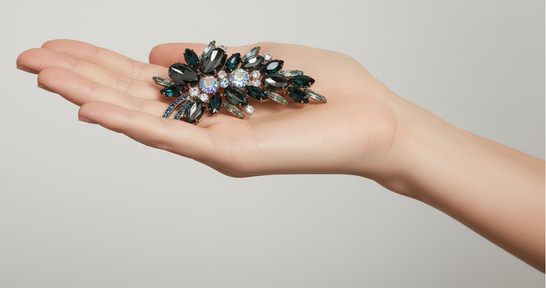 Woman wearing a gray blazer with a brooch on a plain background