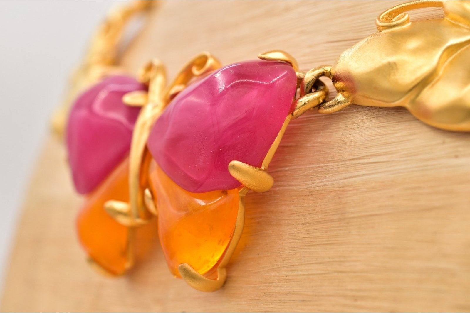 Necklace with pink and orange stones on a wooden surface