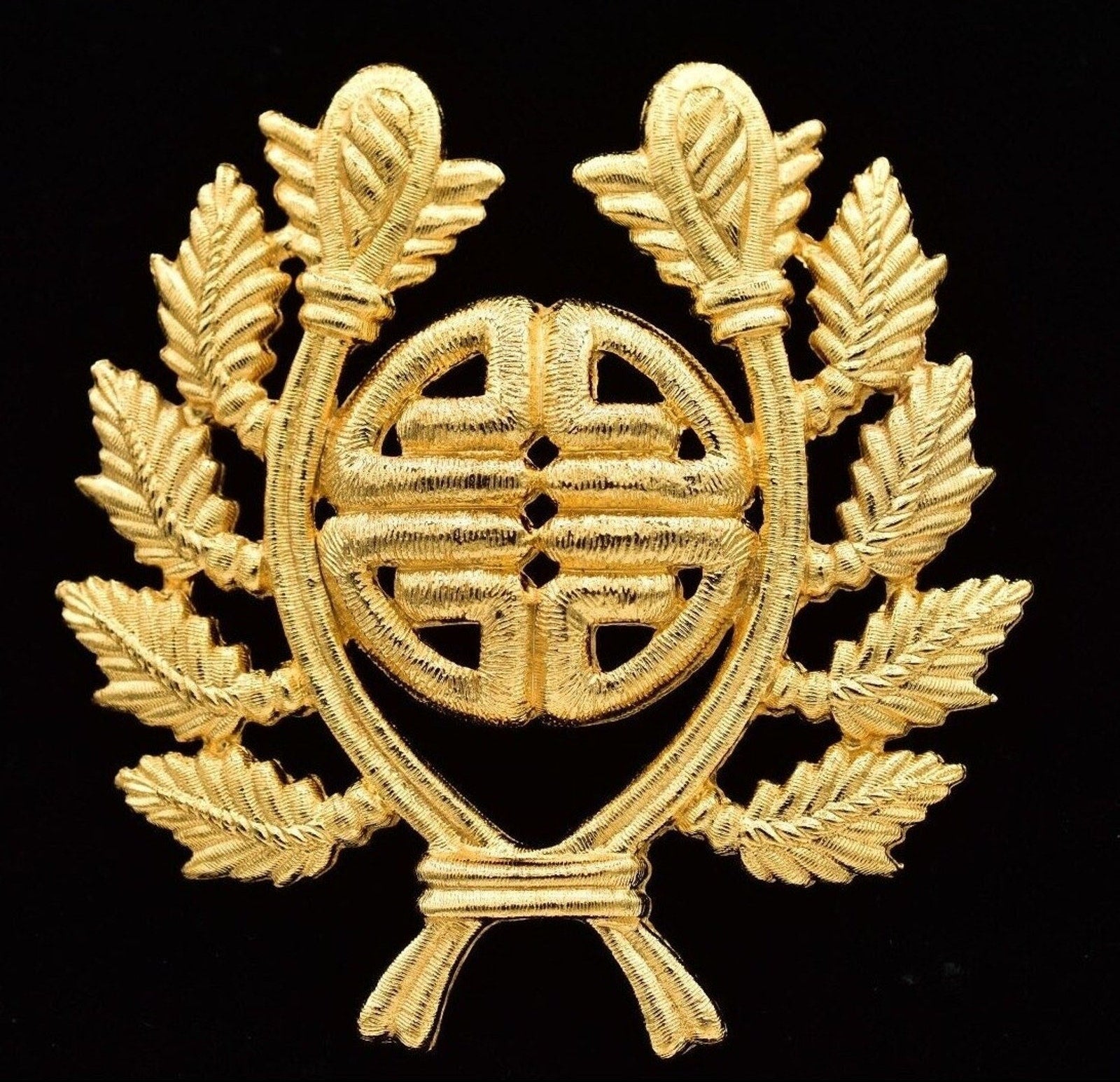 Gold emblem with leaves on a black background