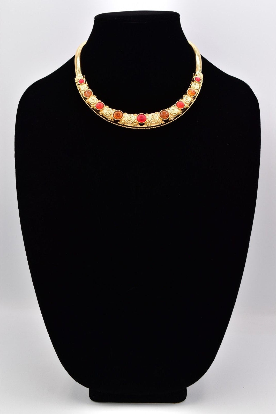 Necklace with colorful beads on a black mannequin bust against a white background