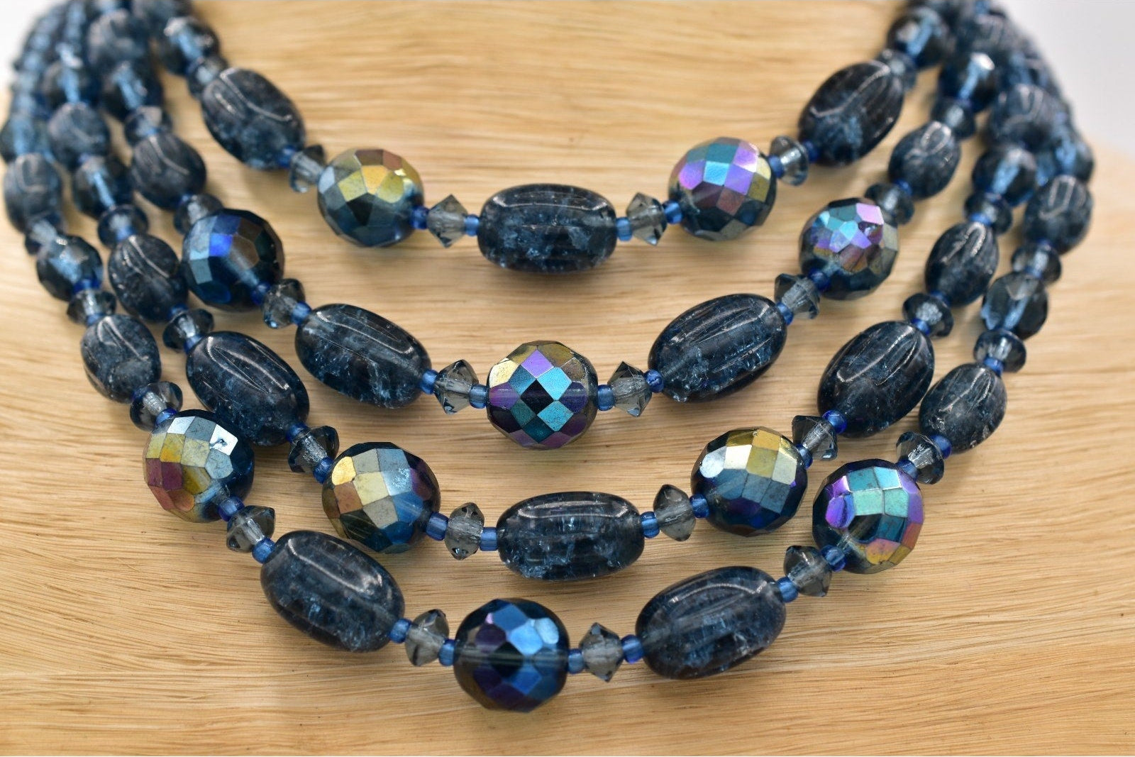 Beaded necklace with blue and multicolored beads on a wooden surface