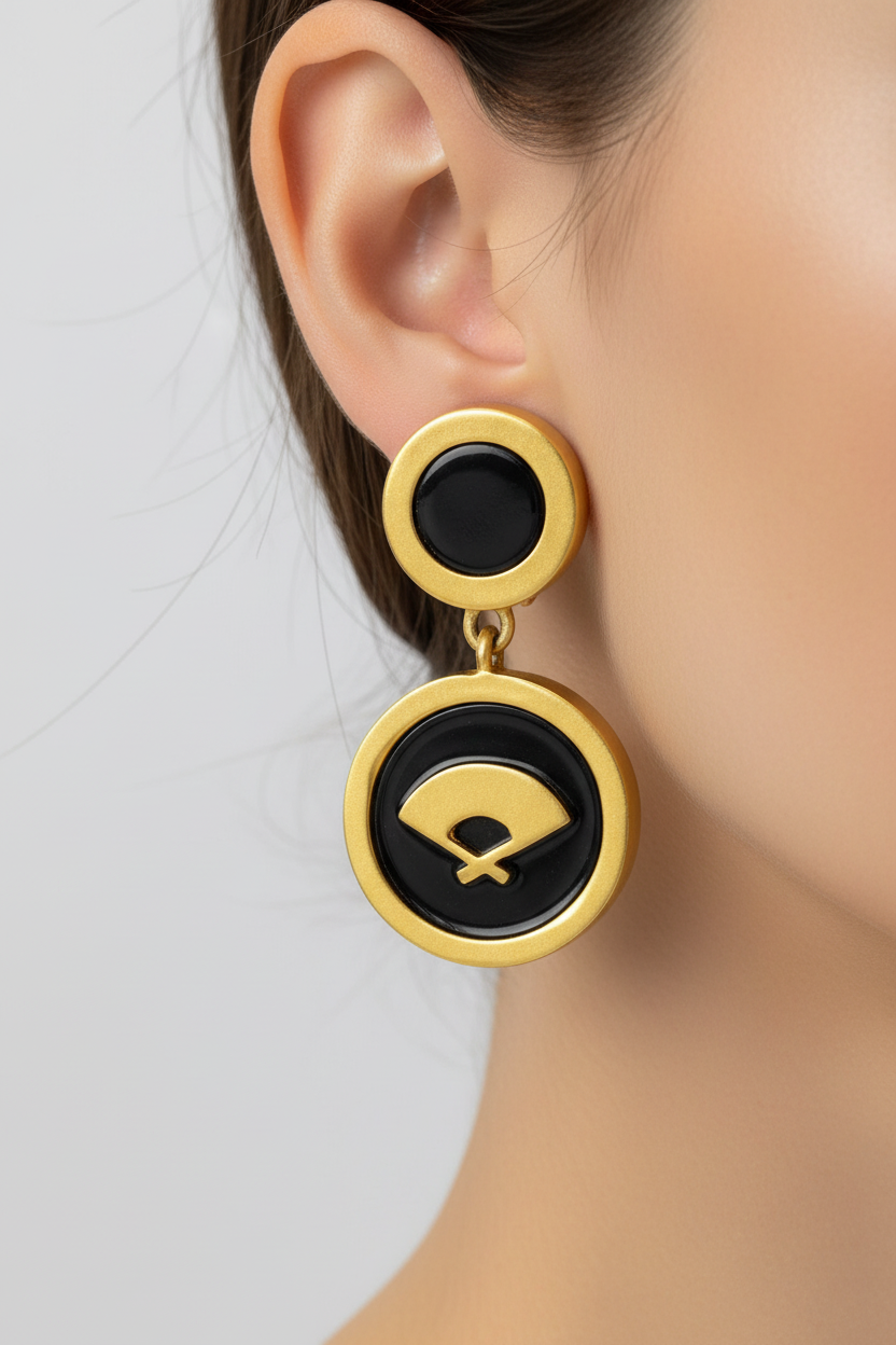 A pair of vintage Karl Lagerfeld matte gold earrings featuring the iconic fan logo, displayed on a stand.