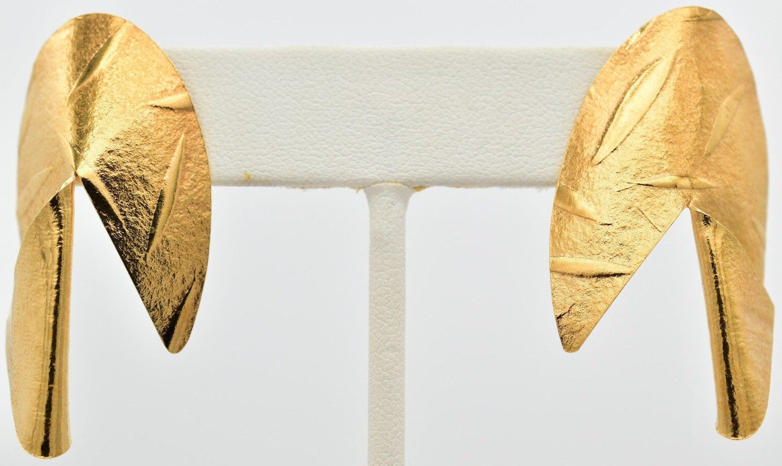 Gold leaf earrings on a white background