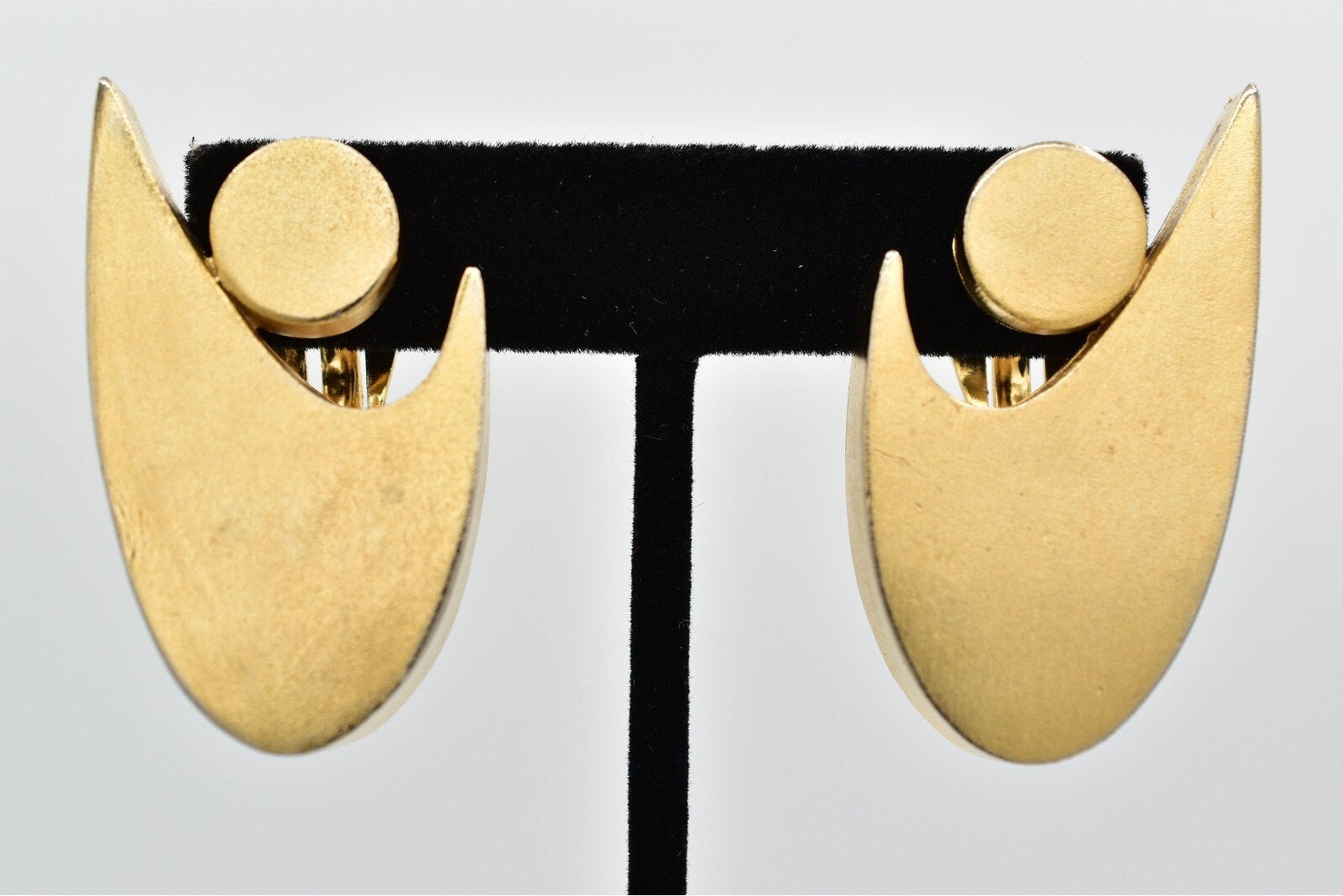 Pair of gold earrings on a gray background
