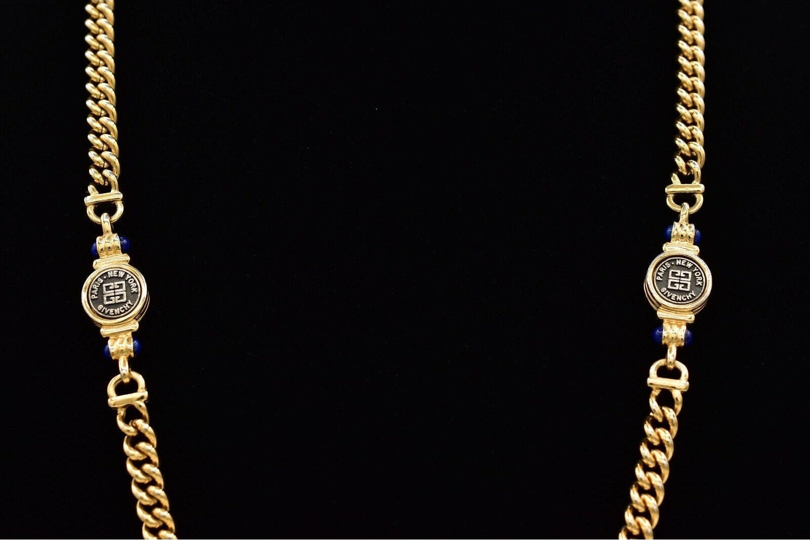 Gold chain necklace with decorative elements on a black background