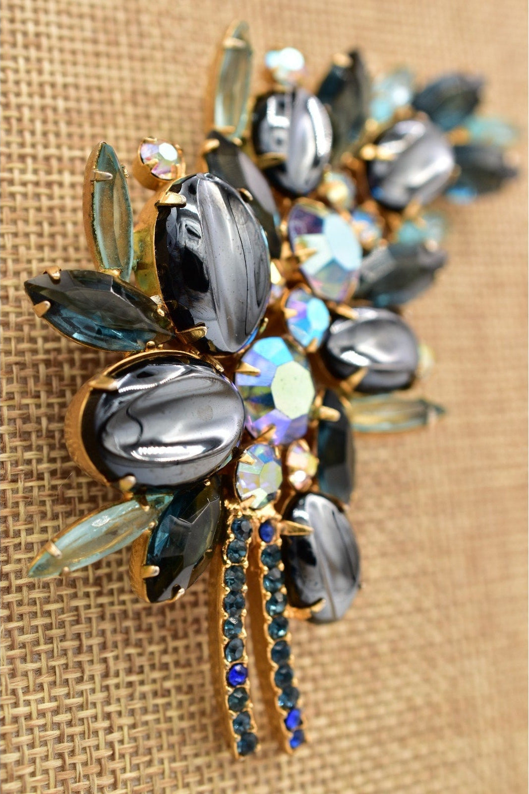 Decorative brooch with gemstones on a textured beige background