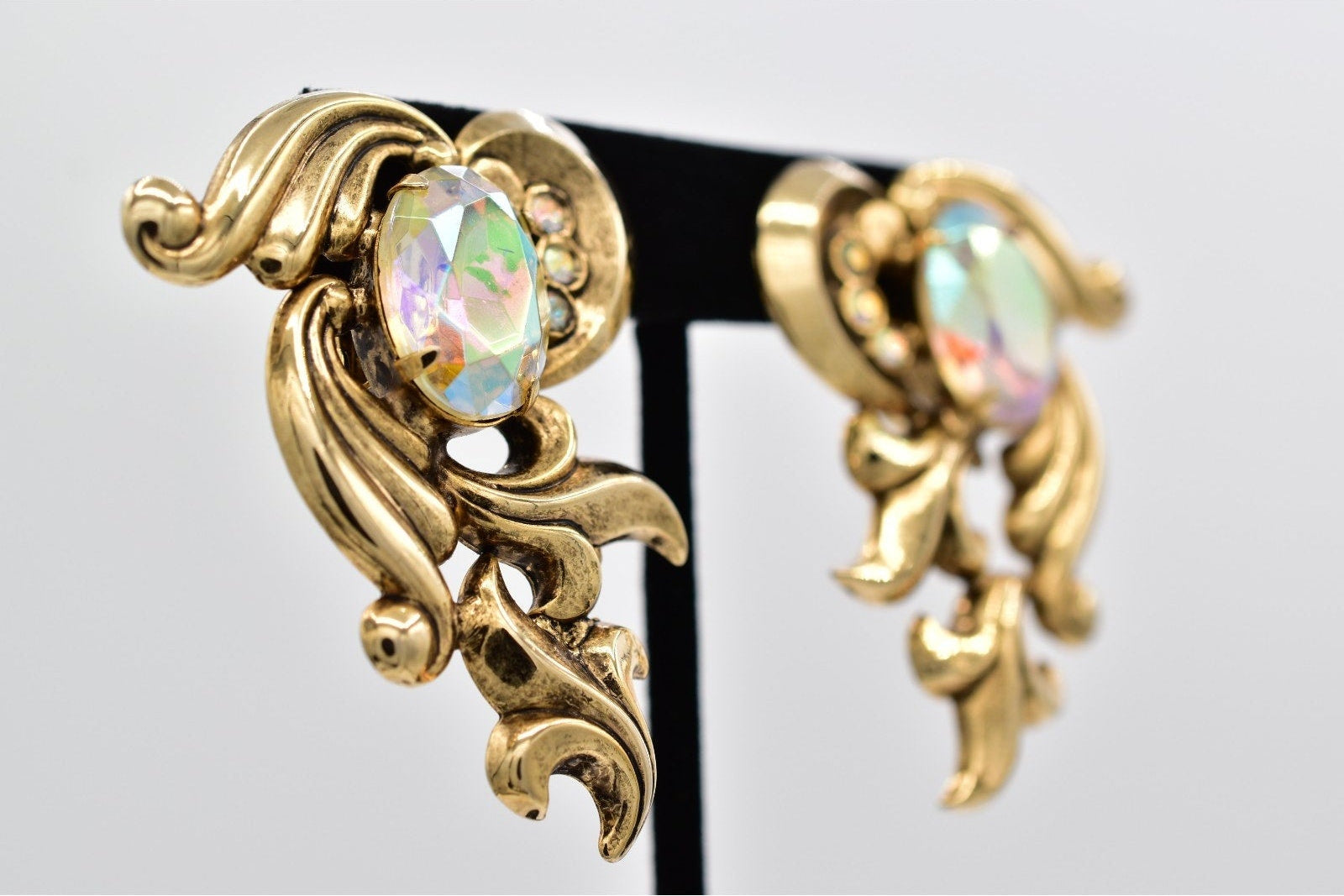 Gold earrings with opal stones on a gray background