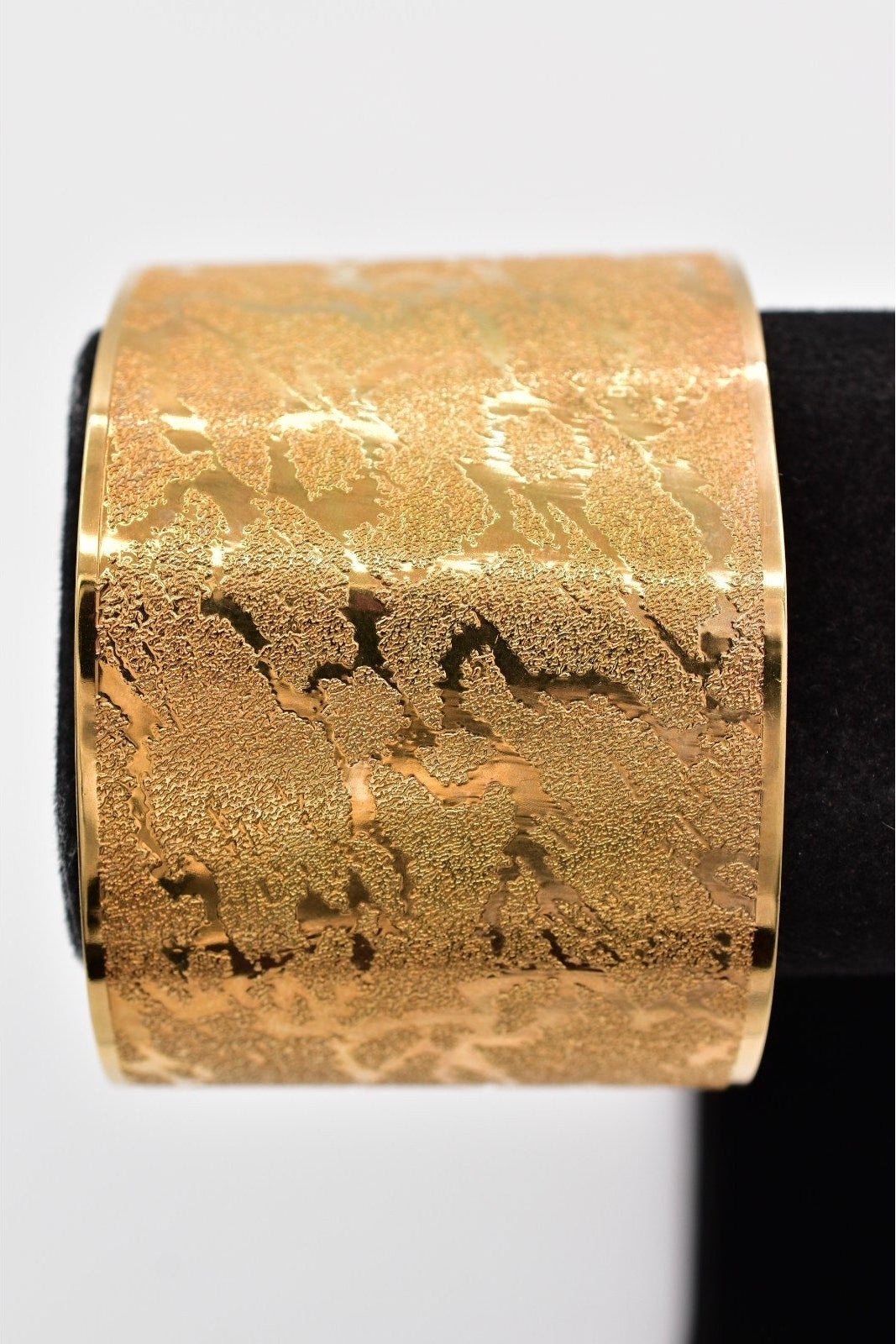 Gold textured bracelet on a white background