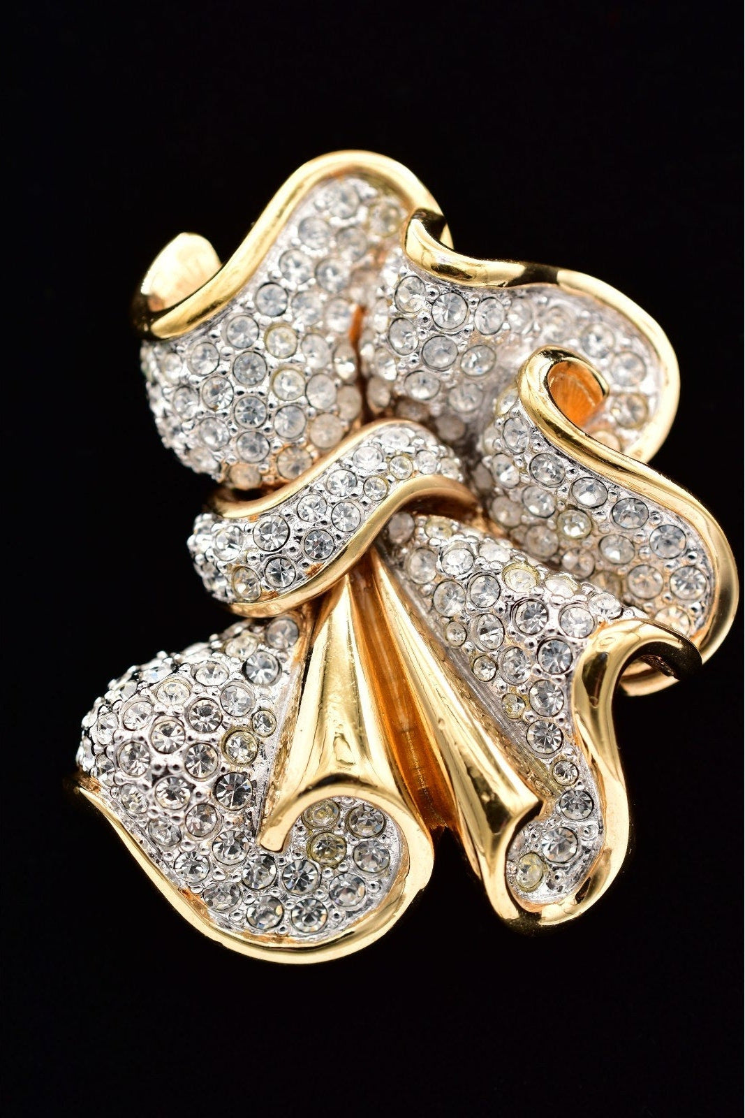 Gold and diamond brooch on a black background