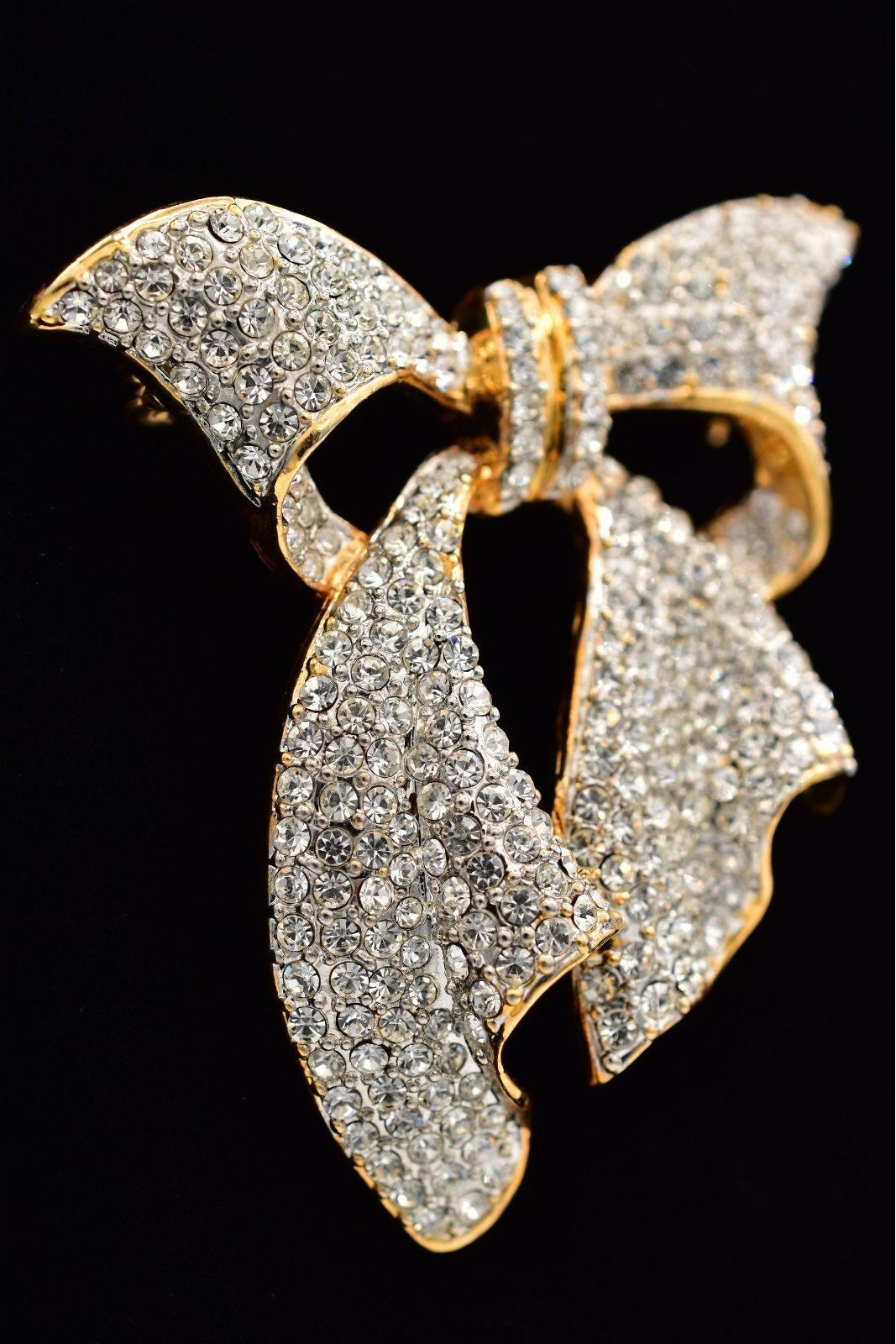 Gold and diamond butterfly brooch on a black background