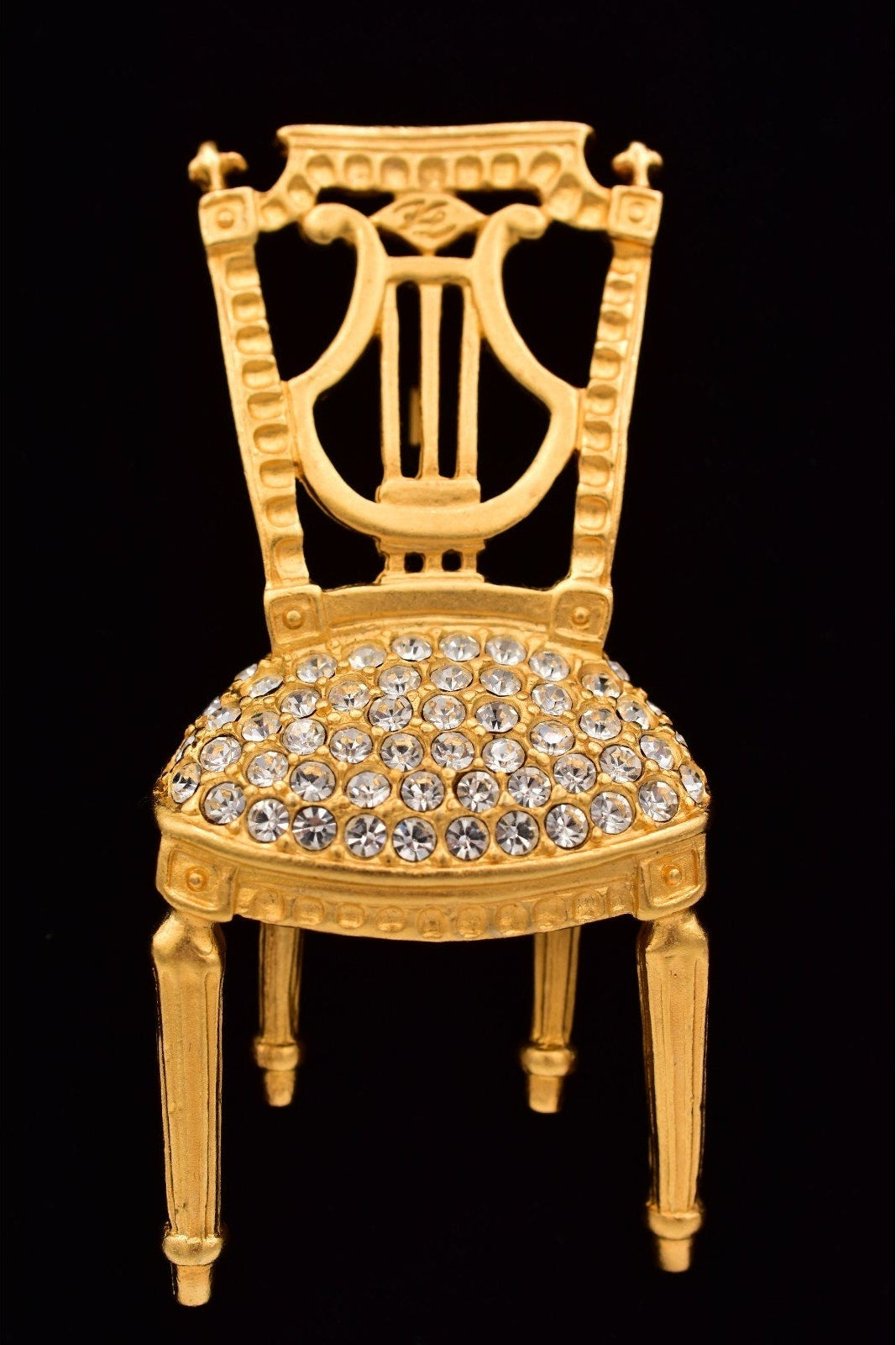 Decorative gold chair with crystal embellishments on a black background