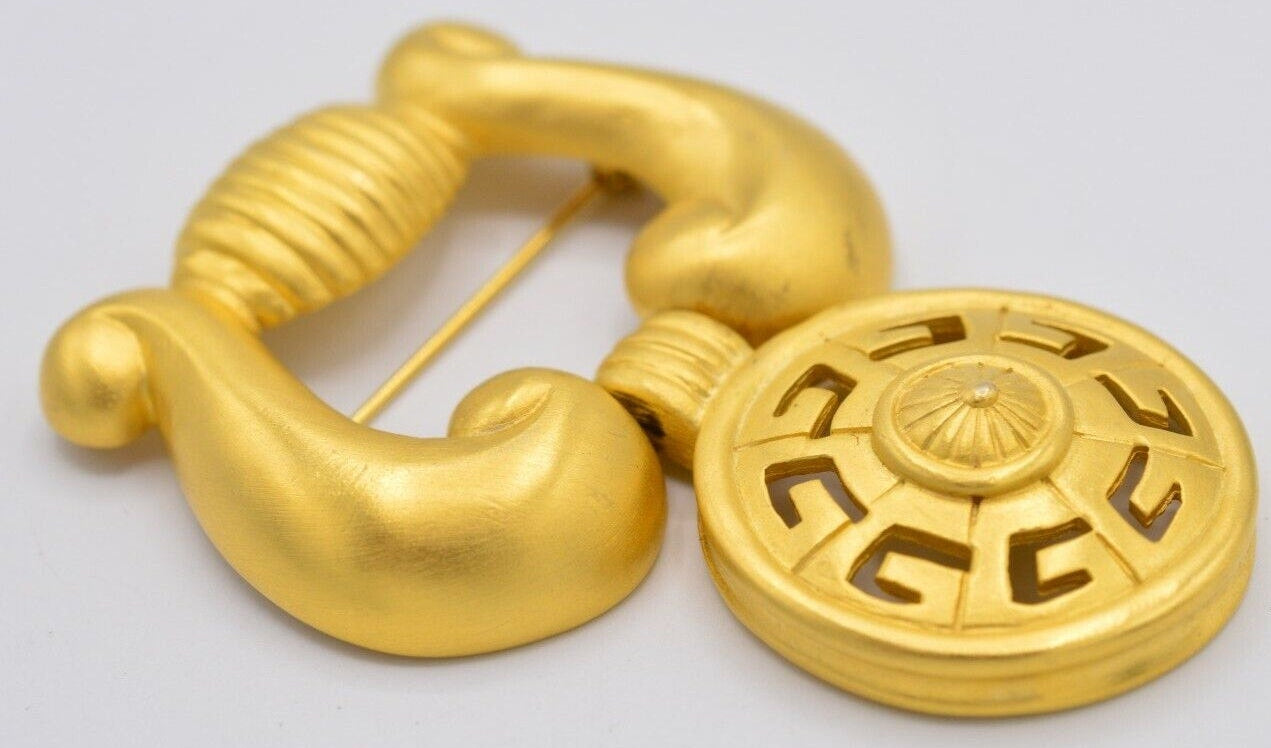 Vintage Givenchy door knocker brooch on a white background
