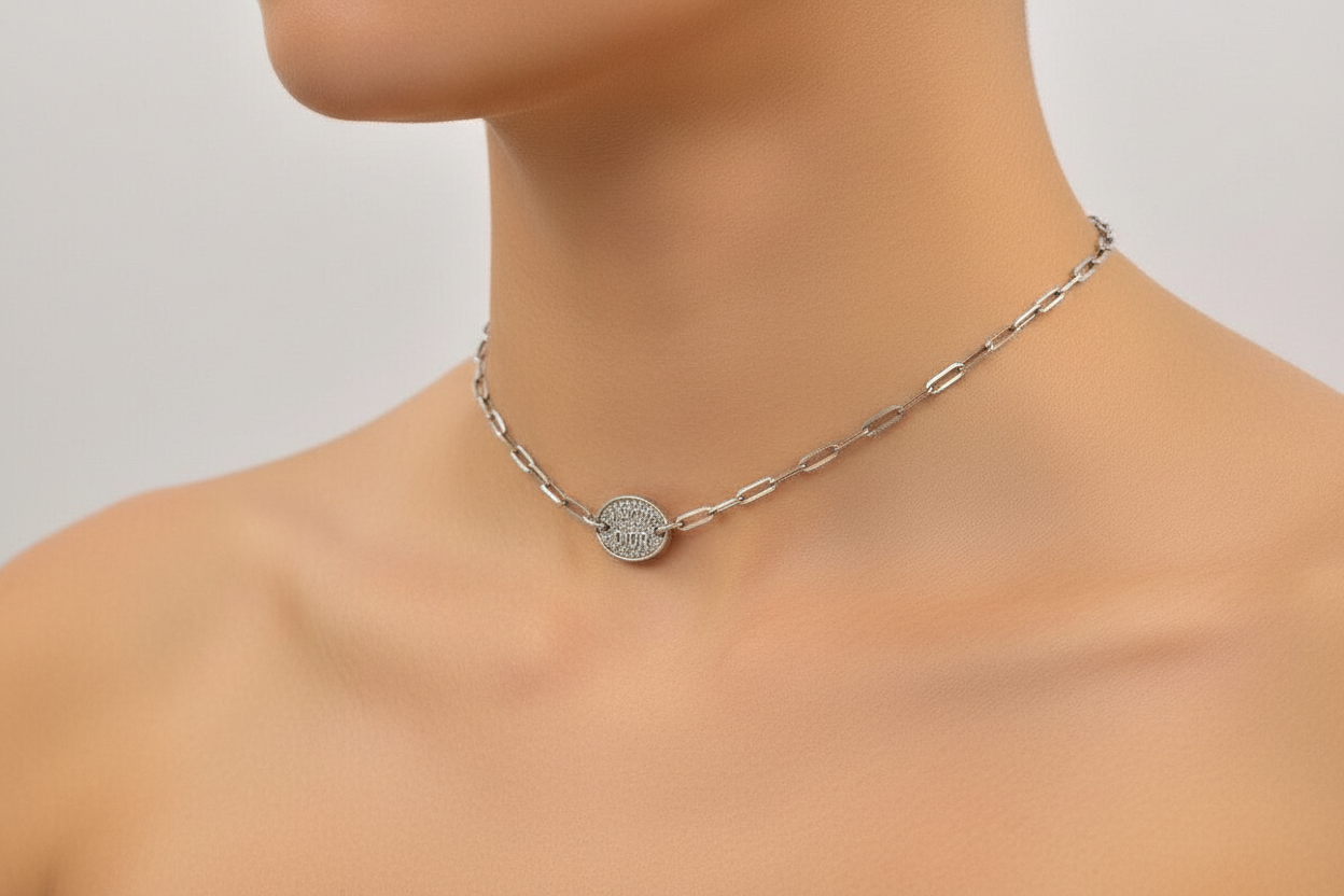 Silver Dior J'Adore necklace with a decorative clasp on a mannequin neck against a neutral background