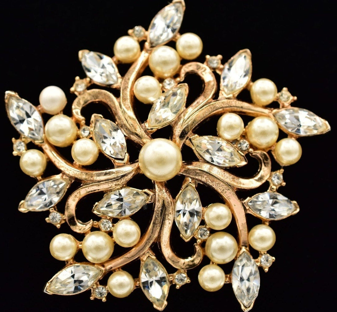 Decorative brooch with pearls and crystals on a black background