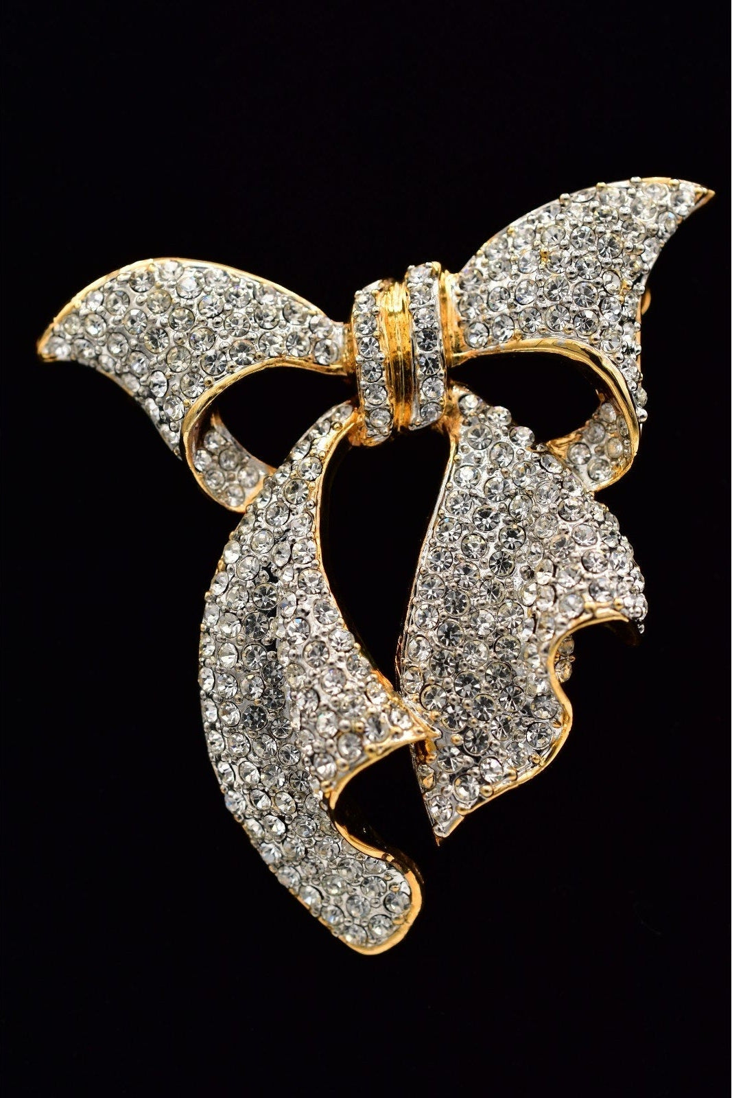 Gold and diamond butterfly brooch on a black background