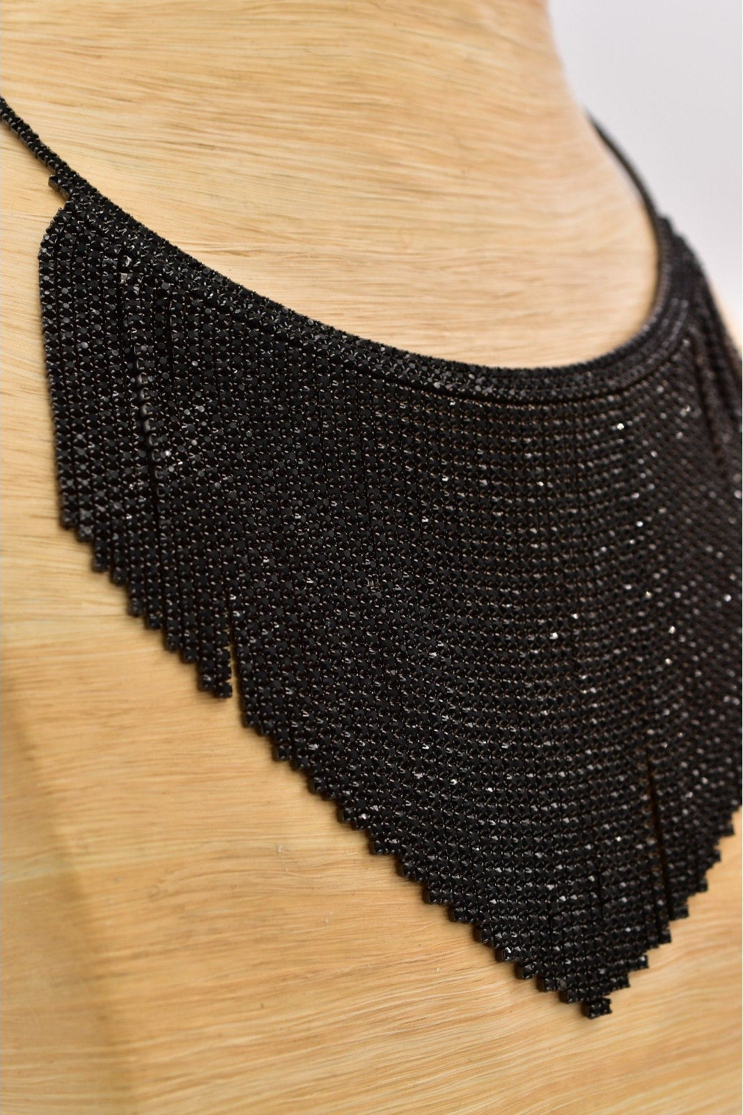 Black beaded fringe on a wooden surface