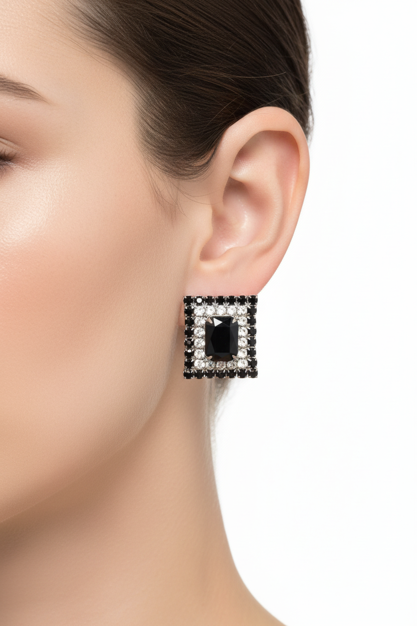 Square-shaped black gemstone with silver border on a ruler for scale