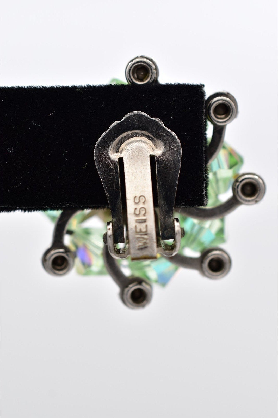 Close-up of a silver clip with 'Weiss' branding on a white background