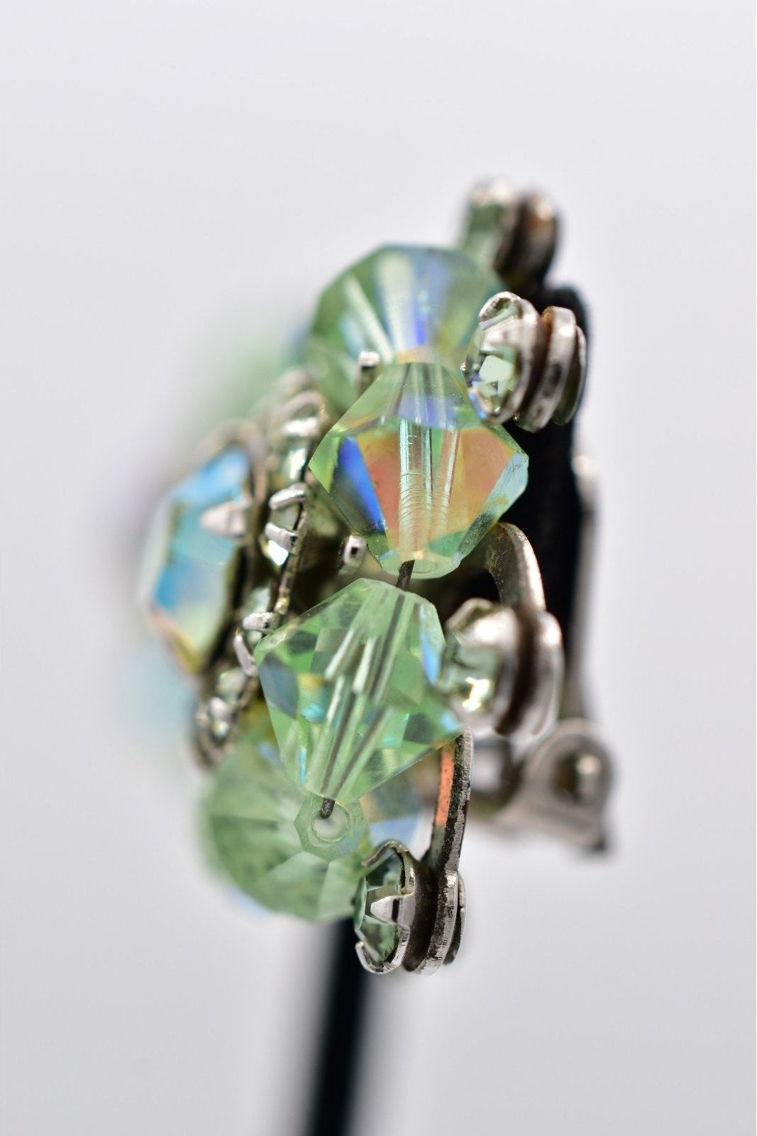 Close-up of a green crystal earring on a white background