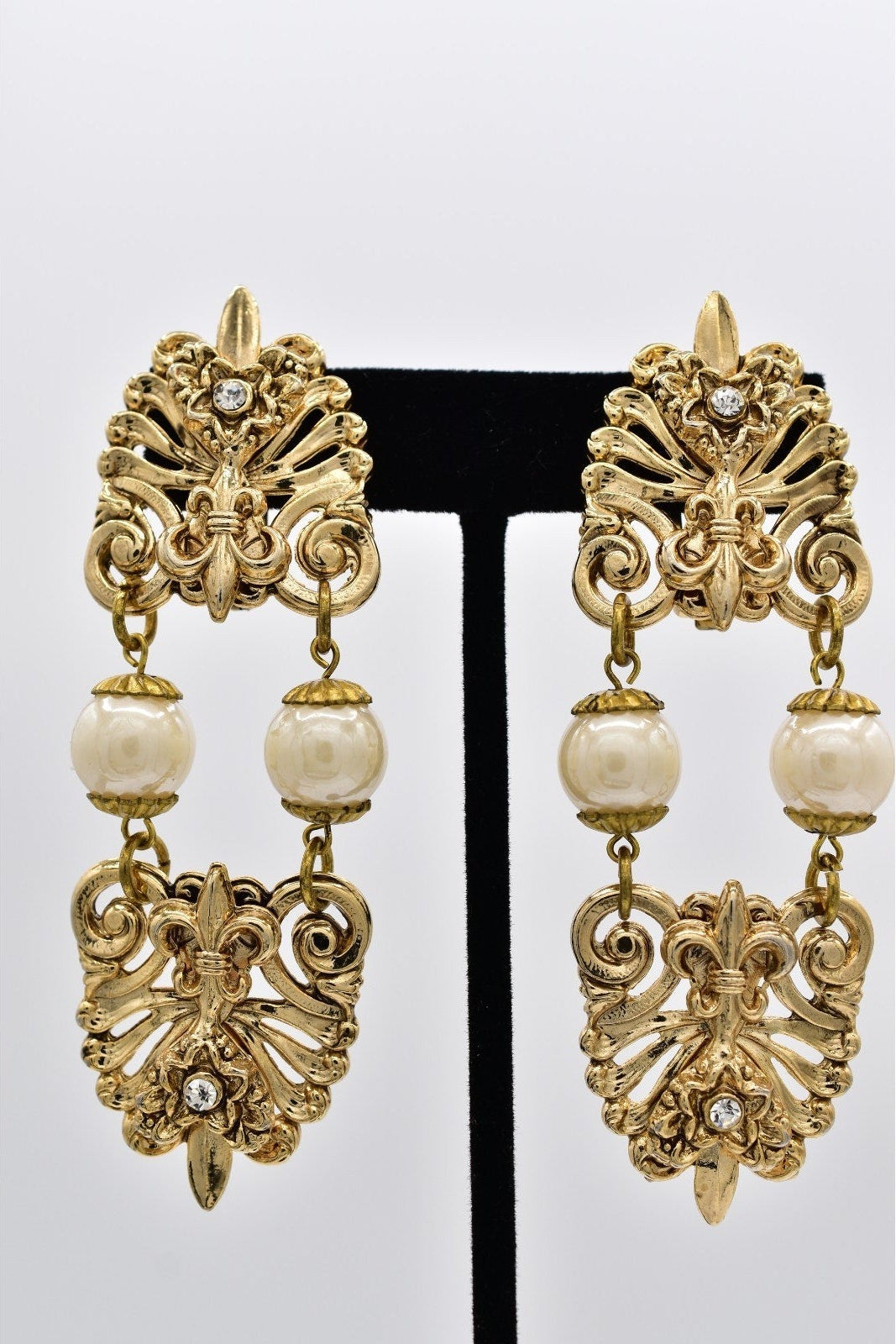 Gold and pearl earrings on a white background