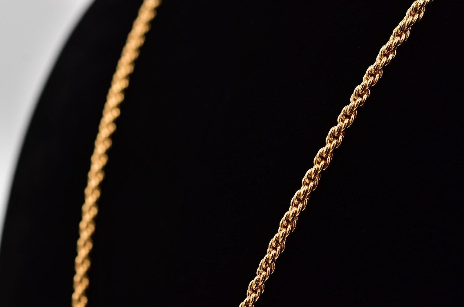 Close-up of a gold chain on a black background
