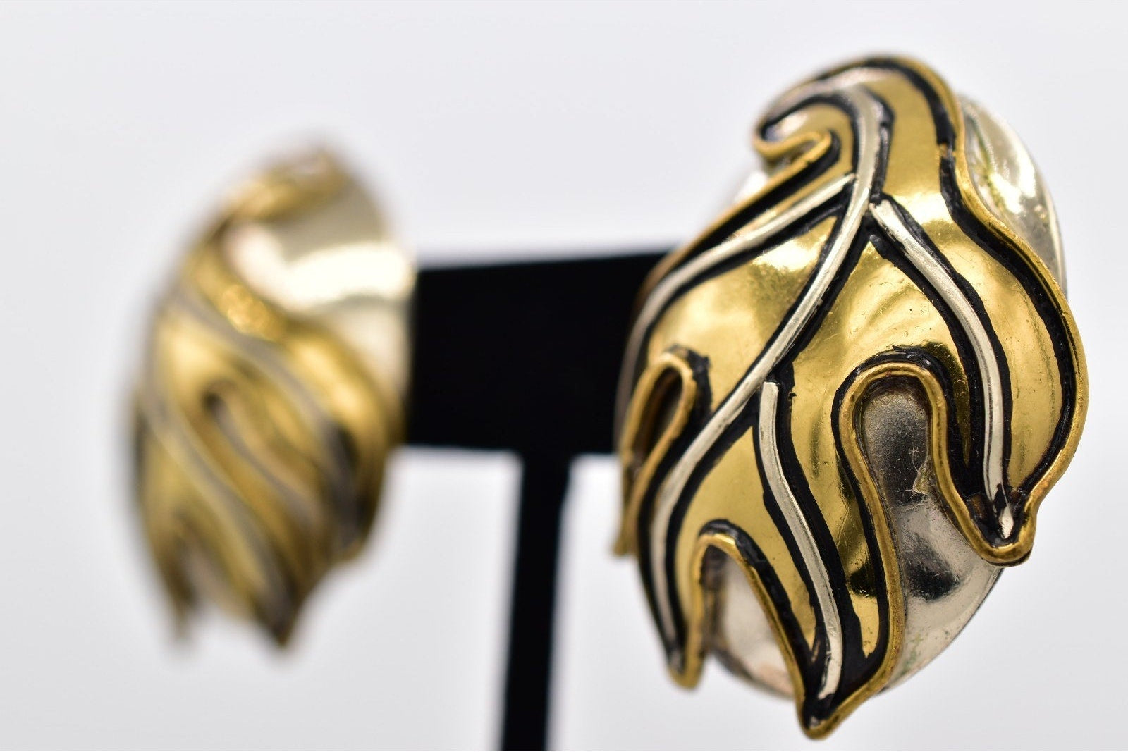 Gold and black cuff bracelet on a white background